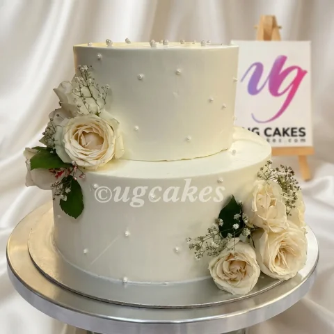 White Double Tier Wedding Cake with Roses and Baby Breath
