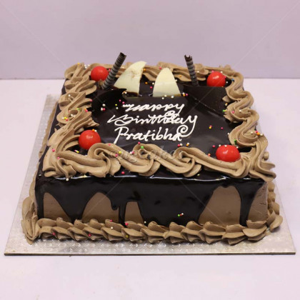 Square Chocolate Cake with Cherries and Chocolate Garnish